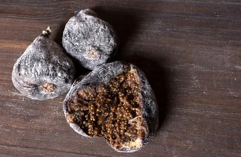 Close up view of three floured dried figs, one of them open Stock Photos