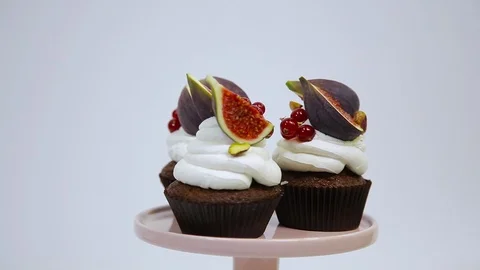 Close up view of three spinning cupcakes, decorated with white cream cheese Stock Footage 106614552