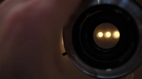 Close up view through the rear side of a camera lens with light reflections in Stock Footage 331013647