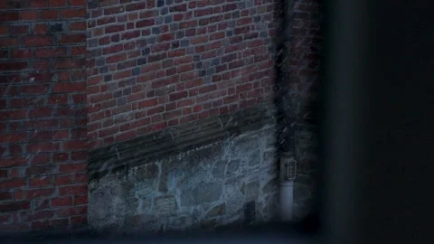 Close-up view through window toward brick wall exterior. Moody urban scene with Video stock 332738272