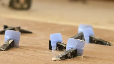 Close-up view of tile leveling system wedges on a floor Stock Footage 346449623