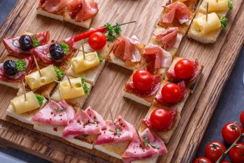Close view of tiny spanish tapas with jamon, sausage, cheese and wine Stock Photos