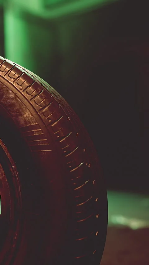 Close up view of a tire against a green background in a workshop Stock Footage 341269010