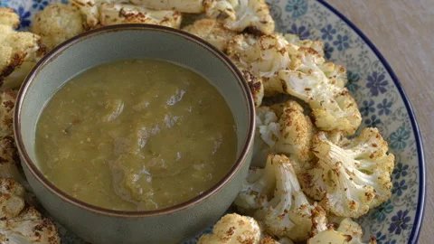 Close up view of  tomatillo salsa and roasted cauliflower. Stock Footage 277419241