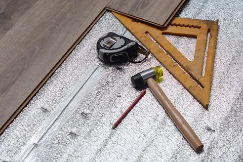 Close-up view of tools and materials used for laminate flooring installation. Stock Photos