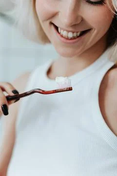 Close up view on toothbrush with toothpaste in smiling blonde woman hand Stock Photos