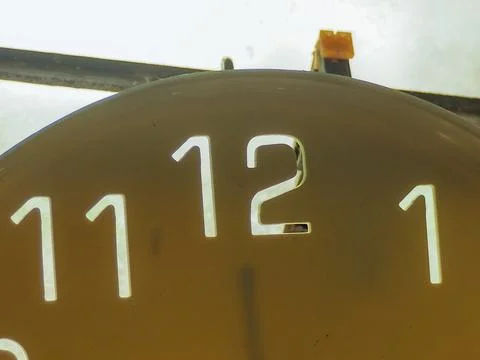 Close-up view of the top of a retro clock face showing the numbers Stock Photos