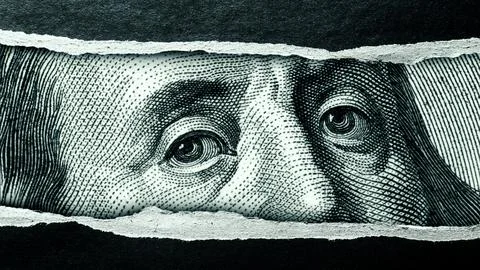 Close-up view of a torn section of a dollar bill revealing the face of Benjamin Stock Photos