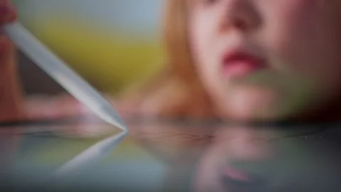 Close-up view of touch stylus used by little girl to draw on tablet. Toddler Stock Footage 261467455
