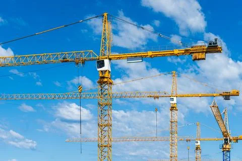 Close view of tower cranes against blue sky for construction site engineeri.. Stock Photos