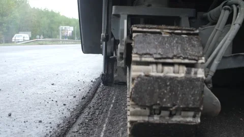 Close-up view of tracked heavy-duty cutter machine cutting asphalt surface Stock Footage 158050154