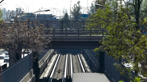 Close up view of train entering a tunnel, passing beneath footbridge Stock Footage 98115430