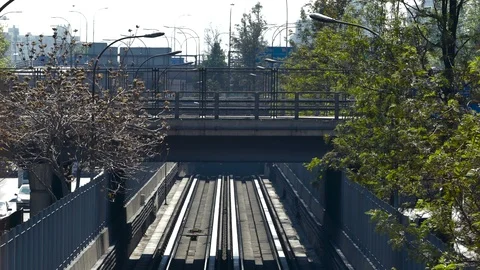 Close up view of train leaving a tunnel, passing beneath a footbridge Stock Footage 98119848