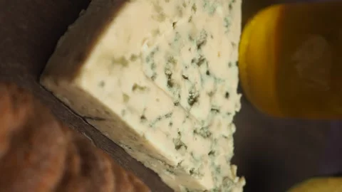 A close up view of a triangle slice of blue cheese next to a jar of honey. Stock Footage 332058181