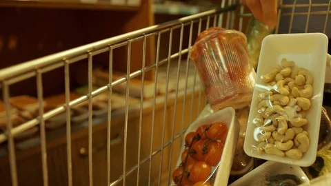 Close up view of trolley in the vegetable department where man putting the Stock Footage 76999666