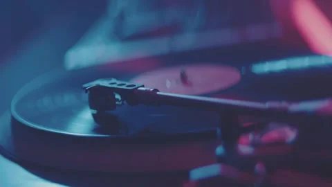 Close up view of turntable playing vinyl record in dark room with colorful .. Stock Footage 337536872