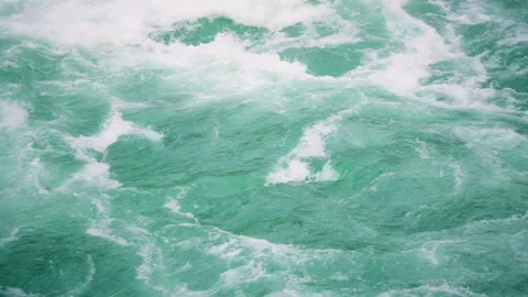 Close-up view of turquoise water currents with foamy white waves, showcasing Vidéo 295168482