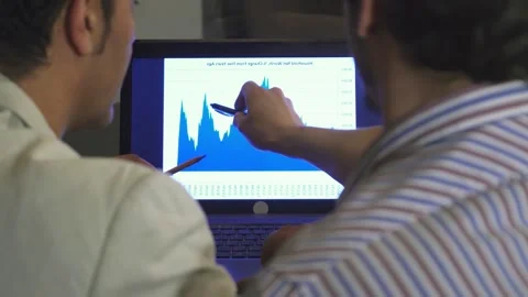 Close-up view of two businessmen analyzing a diagram on a laptop screen Stock Footage 311992509