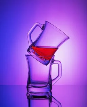 Close view of two empty crystal cups with the rest of tea on the gradient blu Foto stock