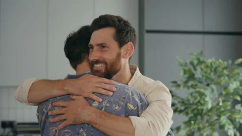 Close view of the two gay mans happy hugging together in their new apartment Stock Footage 203976347