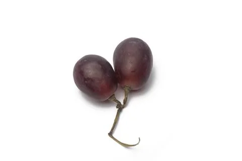 Close-up view of two grapes on white background from 45 degrees. Stock Photos