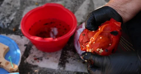 Close up view of two old hands with black gloves cleaning red roasted pepper for Stock Footage 207719031