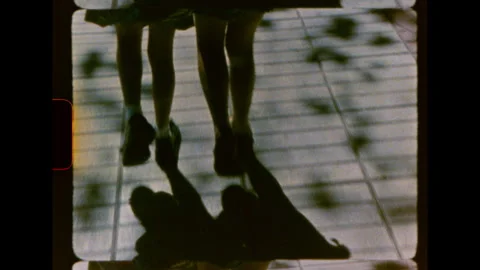 Close up view of two pairs of child legs walking vintage super 8mm Stock Footage 346165701