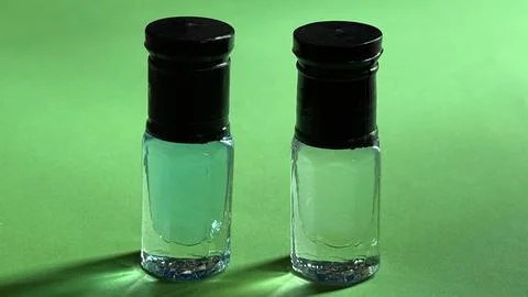 Close up view of two small transparent bottles with black caps containing lig 库存照片