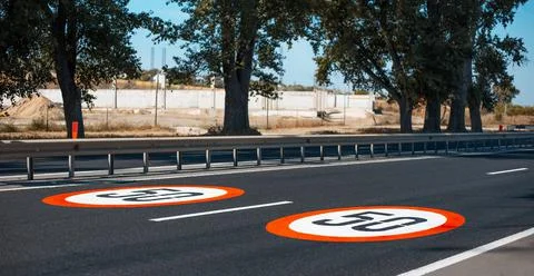 Close-up view of two speed limit signs with 50 km per hour, painted on asphalt. Stock Photos