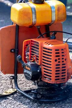 Close-up view of the two strokes engine of the orange grass cutting or trimme Stock Photos