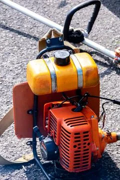 Close-up view of the two strokes engine of the orange grass cutting or trimme Stock Photos