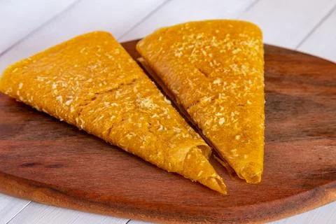 Close view of two yellow triangular fruit pastille pieces sprinkled with co.. Stock Photos