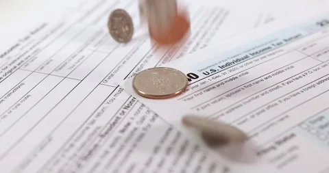 Close up view of USA mint coins on tax documents. Pouring money in to taxes.. Video stock 277614935