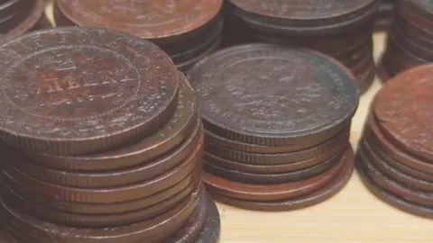A close-up view of various coins stacked on a wooden surface, showcasing di.. Stock Footage 319433936