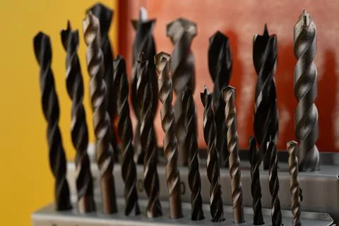 Close-up view of various drill bits organized in a holder against a colorfu.. Stock Photos