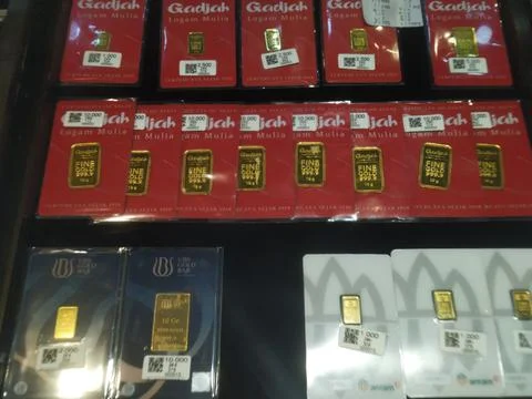 A close-up view of various gold bars and ingots displayed in red and clear .. Fotos Stock