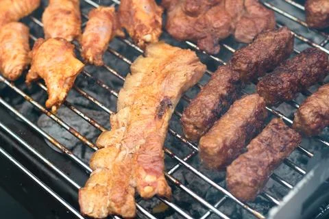 Close-up view of various types of meat cooking on a hot charcoal grill Stock Photos