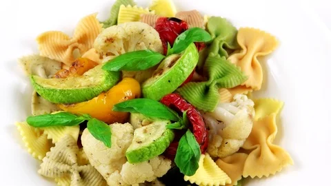 Close-up view of Vegetarian Bow tie pasta with grilled vegetables and basil leaf Stock Footage 73654641