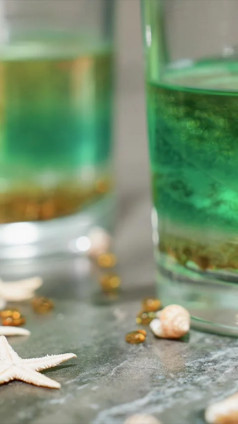 Close up view of vibrant green colored fluid in glass accompanied by small Stock Footage 345725228