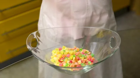Close-up view of vibrant orange and green sugar cube sweets placed in a round Stock Footage 318441991