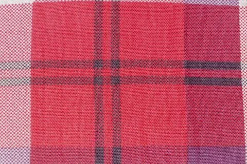 A close-up view of a vibrant red and black tartan pattern fabric, showcasing its Stock Photos