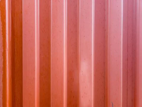 A close-up view of a vibrant reddish-orange corrugated metal surface, possibl Stock Photos