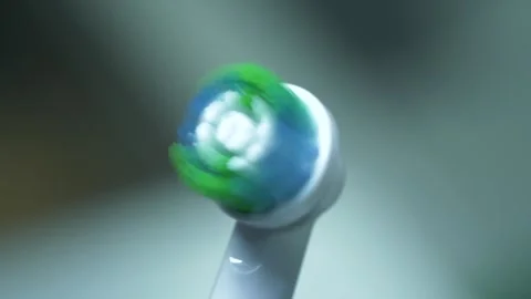 Close-Up View of a Vibrating Electric Toothbrush in Action Against a Blurred Stock-Footage 262790871