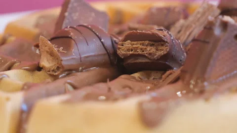 A close up view of a waffle covered in chocolate cream with chocolate pieces. Stock Footage 155747954