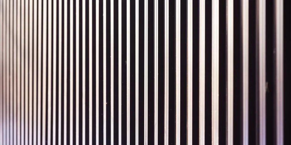 A close view of a wall built from vertical metal slats, creating a repeatin.. Stock Photos