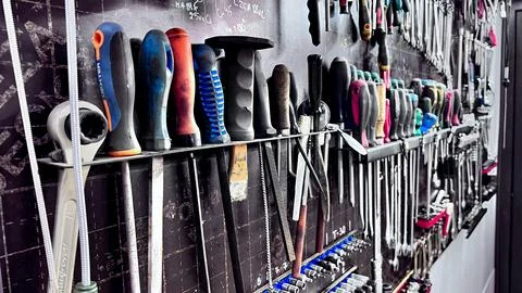 A close-up view of a wall filled with various mechanic tools, including wrenches Stock Photos