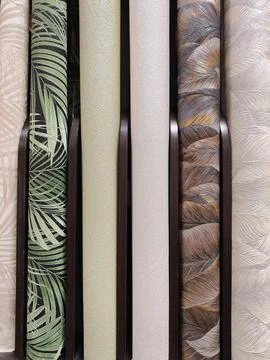 Close-up view of wallpaper rolls in a DIY store, showcasing vibrant pattern.. Stock Photos