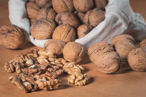 Close up view of walnut kernels and whole walnuts in a cotton bag, Scattered  Stock Photos