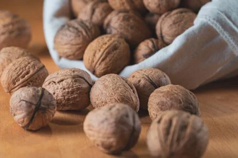 Close up view of walnut kernels and whole walnuts in a cotton bag, Scattered  Stock Photos
