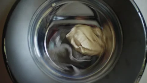 A close up view of a washing machine drum spinning with a load of clothes d.. Stock Footage 334768249
